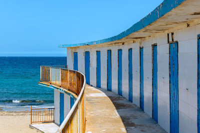 Lifeguard hut on beach against clear blue sky