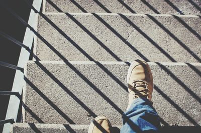 Low section of man standing on tiled floor