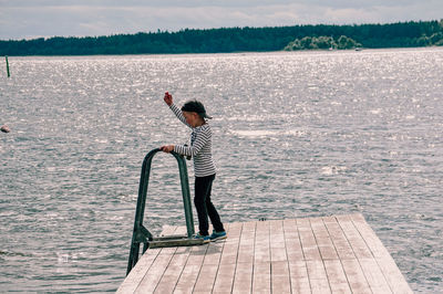 Side view of man standing by sea