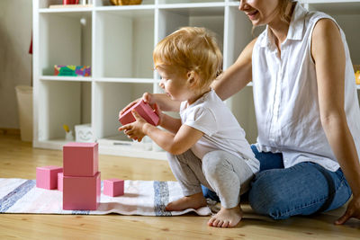 Rear view of father and son sitting on floor