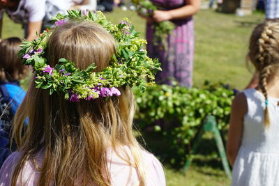 Rear view of girl wearing wreath at park during wedding