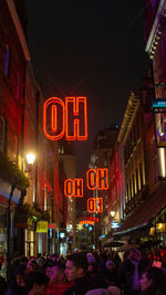 People on illuminated city street at night