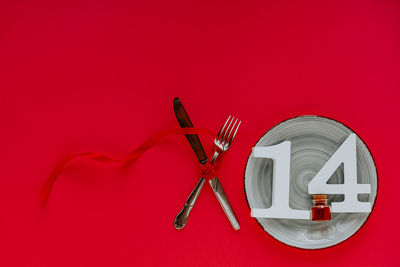 High angle view of lamp on table against red background