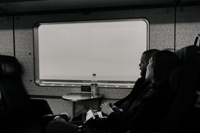 Side view of man and woman sitting on table