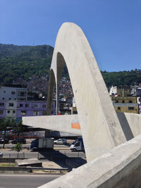 Arch bridge in city against clear blue sky