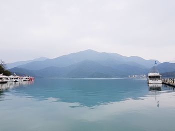 Scenic view of lake by mountains against sky