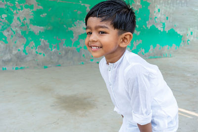 Cute smiling boy standing outdoors