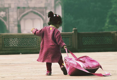 Rear view of woman with girl walking outdoors