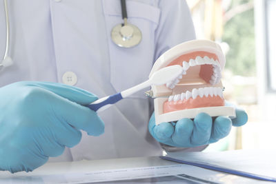 Close-up of dentist working at desk in medical clinic
