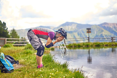 Rear view of children on lake against mountain