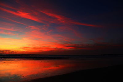 Scenic view of sea against dramatic sky during sunset