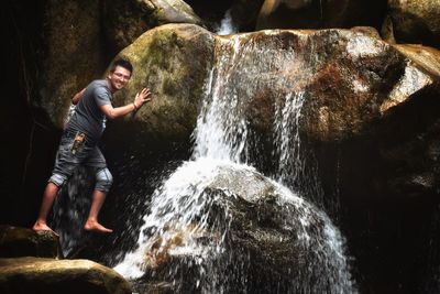 Full length of man looking at waterfall