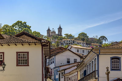Colonial-style houses in the city of ouro preto, minas gerais with baroque church on top of the hill