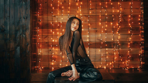 Young woman standing against wall