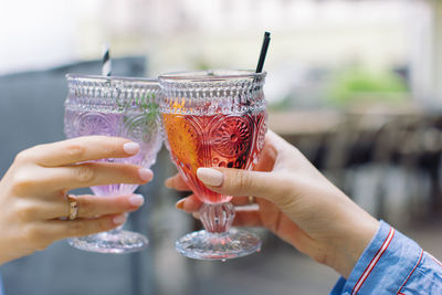 Close-up of hands toasting drinks