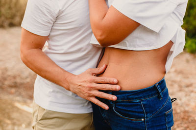 Midsection of couple standing outdoors