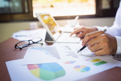 Cropped image of businessman analyzing graph in office