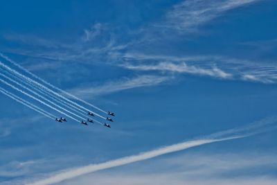 Low angle view of airplanes flying against sky during airshow