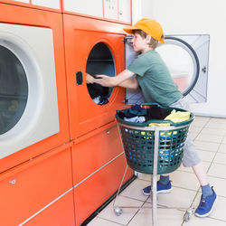 Boy using washing machine in room