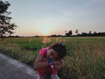 Woman on field against sky during sunset