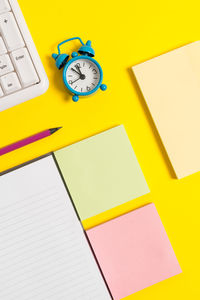 High angle view of yellow clock on table