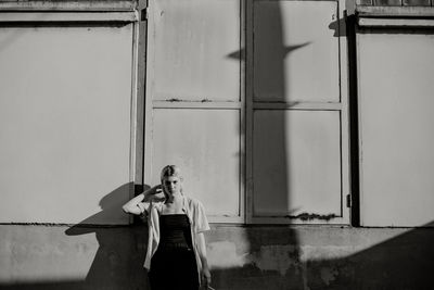 Portrait of woman standing against building