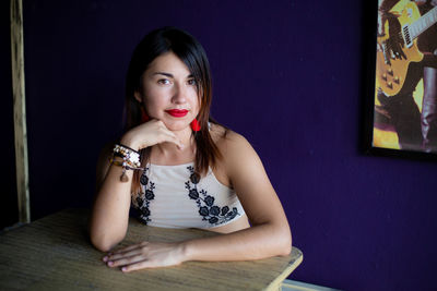 Portrait of young woman sitting on table