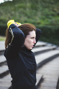 Woman with hand in hair looking away