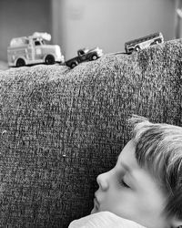 Close-up portrait of boy lying on sofa