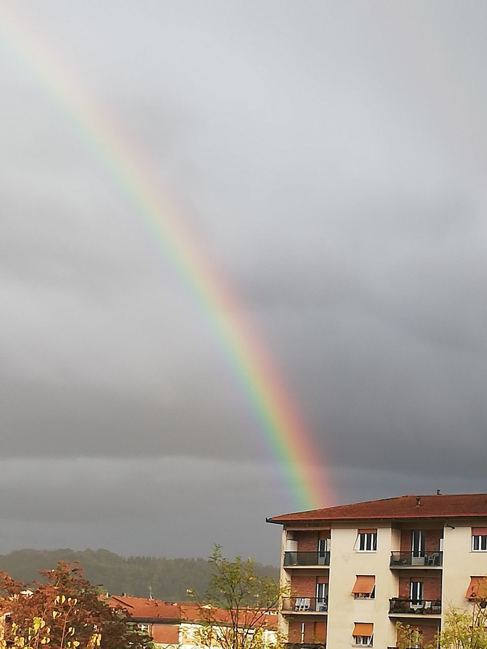 RAINBOW OVER BUILDINGS AGAINST SKY