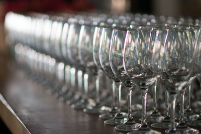 Close-up of wineglasses in row on table