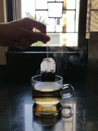 Person holding tea cup on table