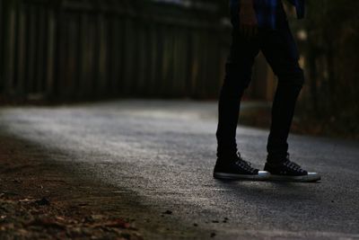 Low section of person walking on road