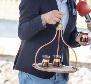 Midsection of man serving turkish tea