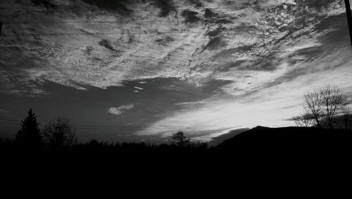 Low angle view of silhouette trees against sky