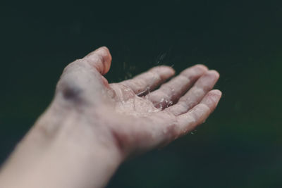 Close-up of water drops on hand against blurred background