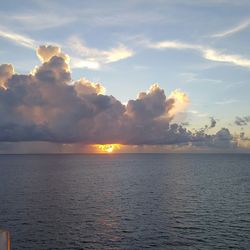 Scenic view of sea against cloudy sky at sunset