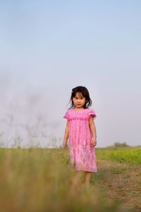 Full length of girl standing on field against sky