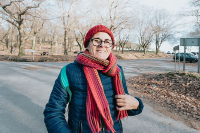 Portrait of smiling woman wearing scarf on road
