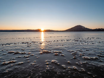 Scenic view of sea against clear sky during sunset