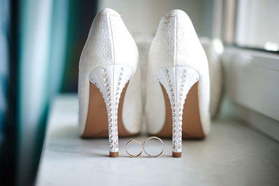Close-up of wedding rings and high heels