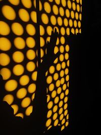 Shadow of person hand on illuminated yellow during sunset