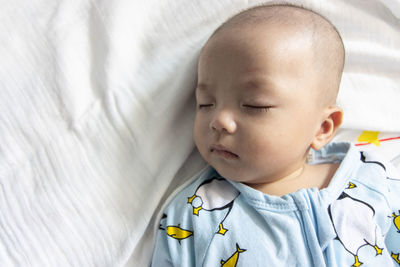 High angle view of baby sleeping on bed