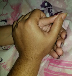 Close-up of baby hand on bed