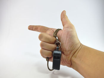 Close-up of hand holding camera over white background