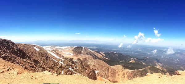 Scenic view of mountains against blue sky