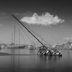 Sailboats in sea against sky