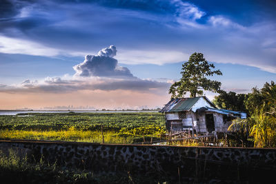 Built structure on field against sky during sunset