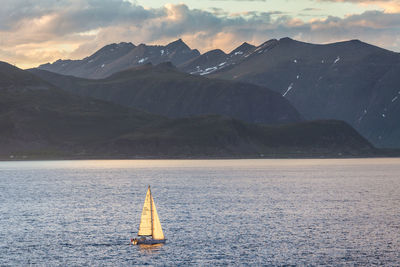 Sailboat on lake against mountains