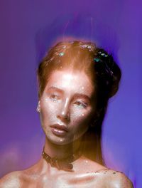 Digital composite image of young woman with glitters against colored background